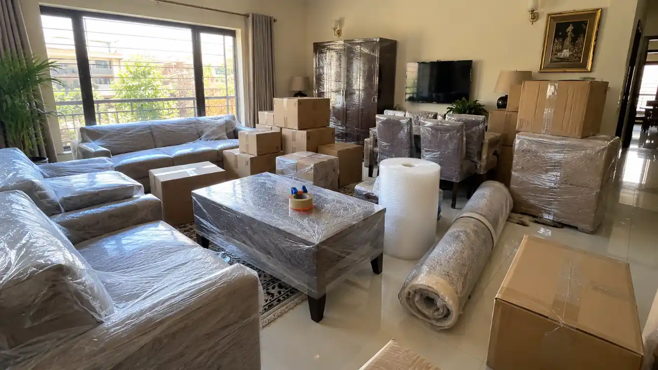 Furniture wrapped in stretch film and boxes packed for moving day